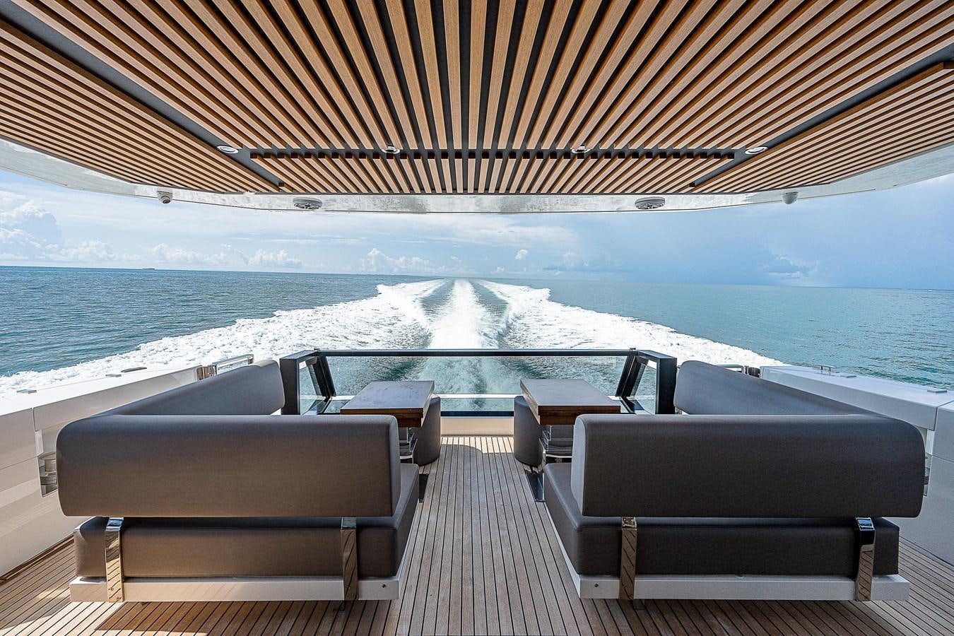 a deck with a view of the ocean and mountains aboard SO SO NICE Yacht for Sale