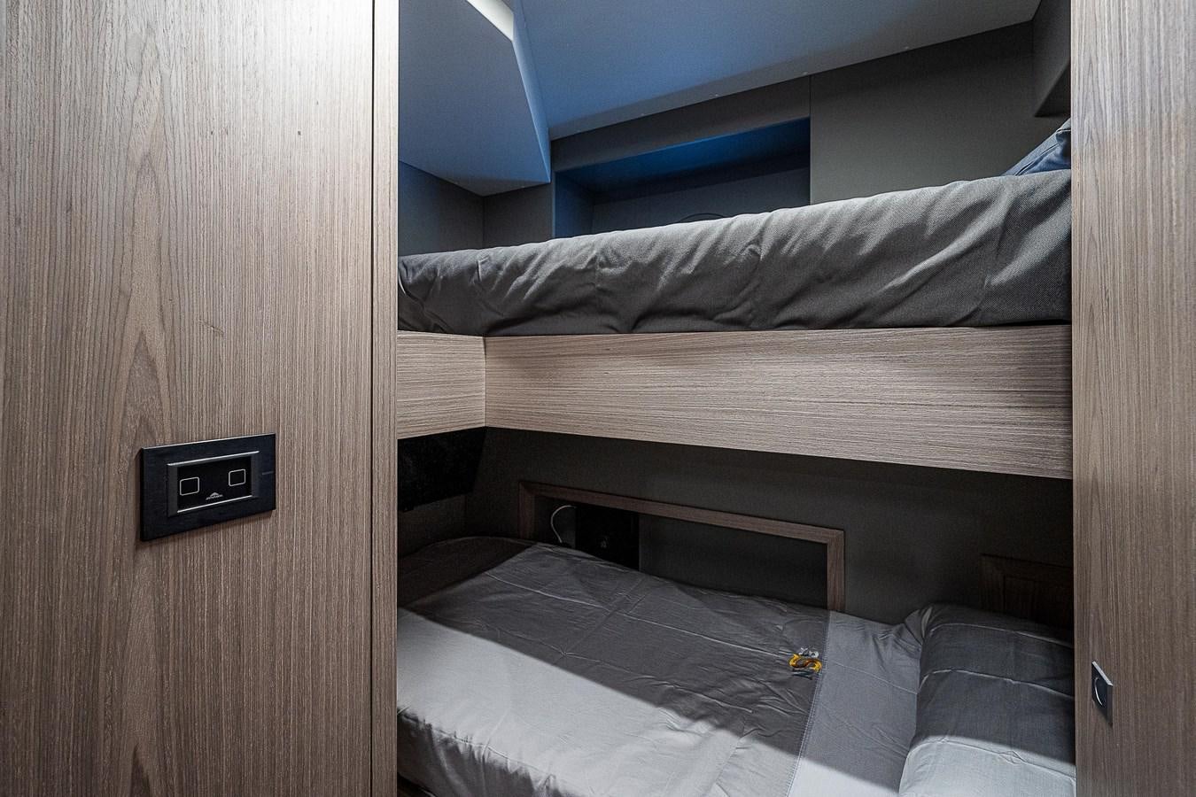 a bed with a phone on the wall aboard SO SO NICE Yacht for Sale