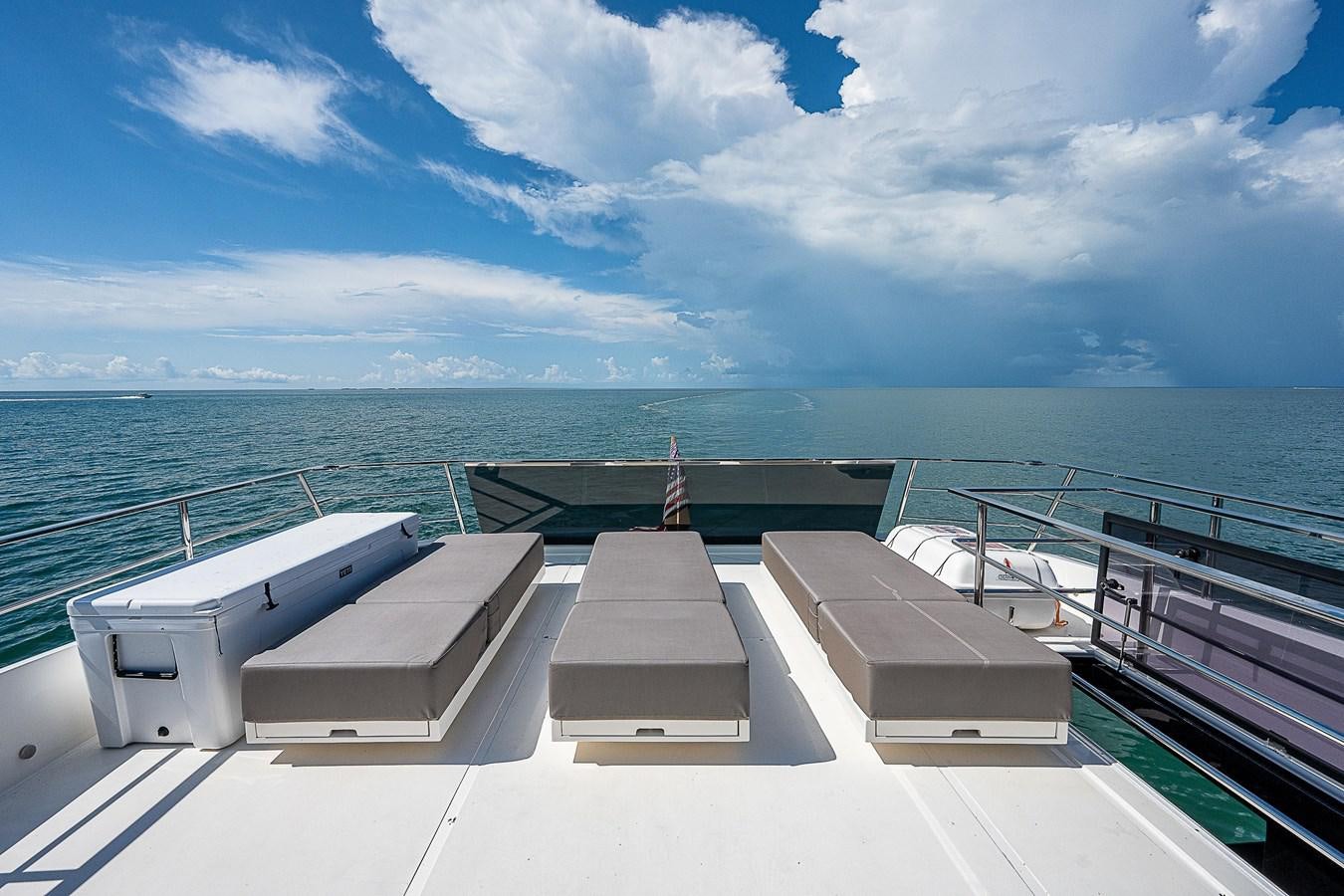 a deck with a railing and a body of water in the background aboard SO SO NICE Yacht for Sale