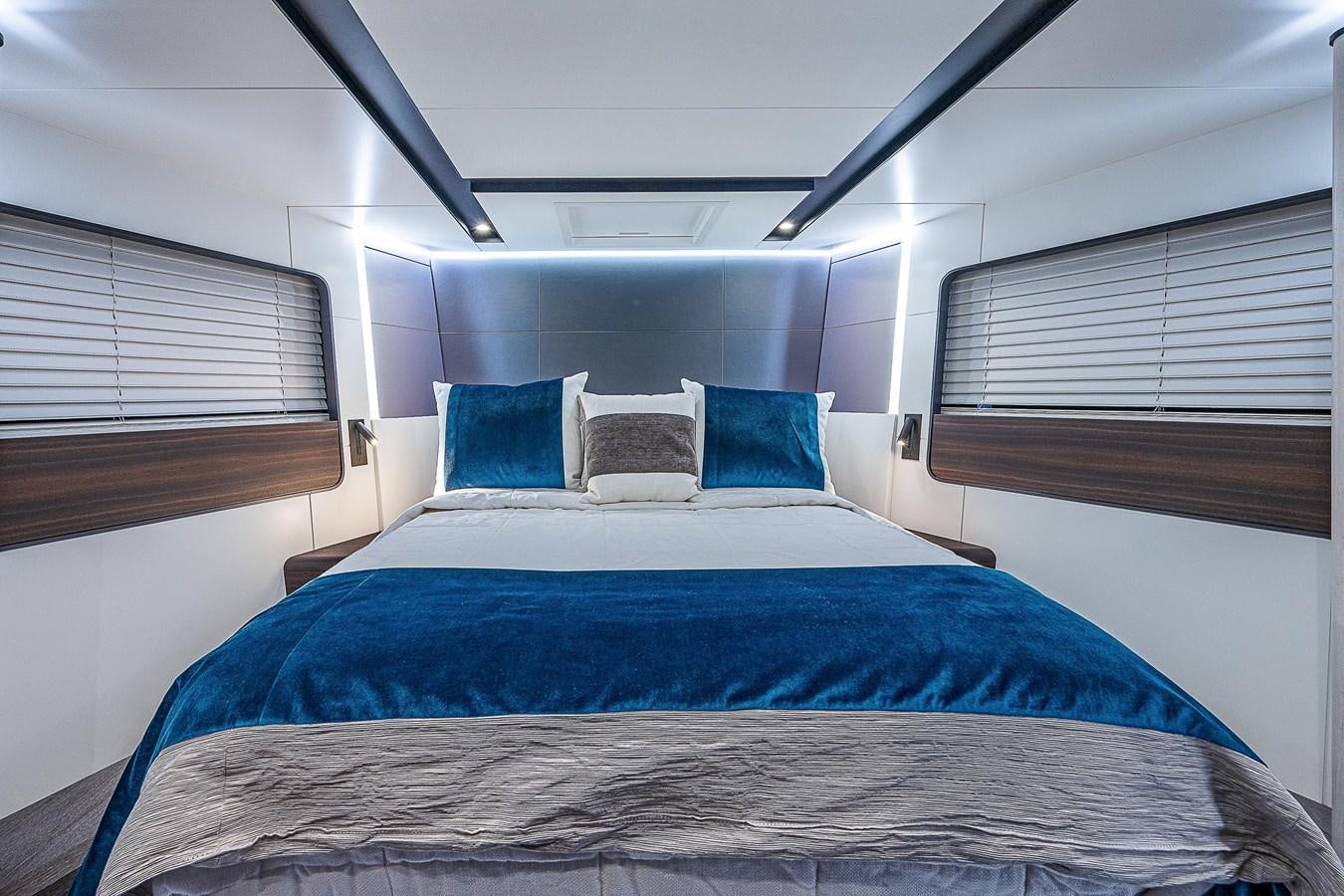 a bed with blue sheets aboard SO SO NICE Yacht for Sale