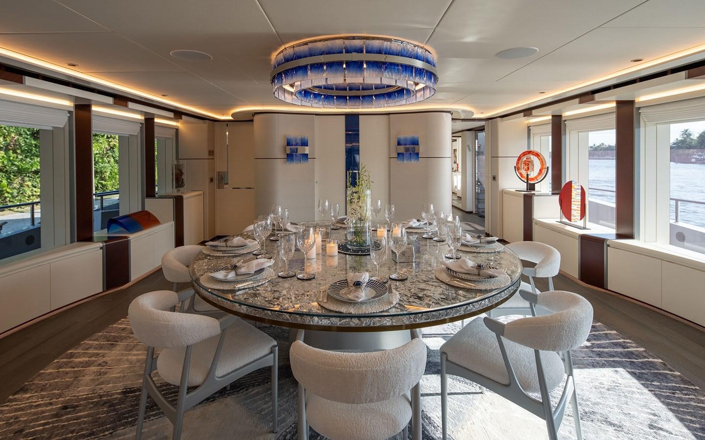 a large dining table with white chairs aboard BOOK ENDS Yacht for Sale