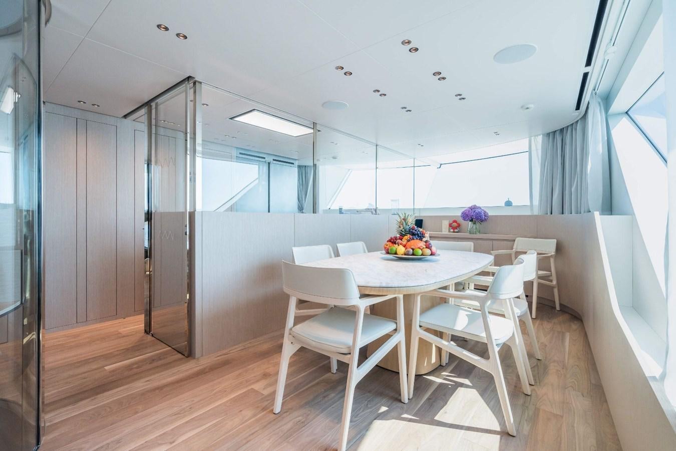 a room with a table and chairs aboard AMI Yacht for Sale