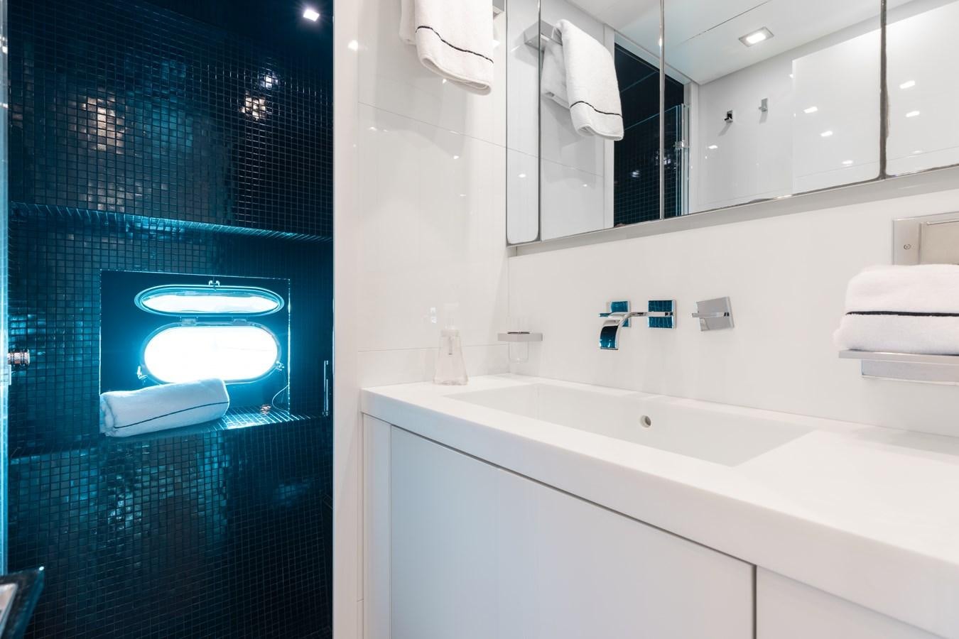 a bathroom with a large blue lit up television aboard VENTURE Yacht for Sale