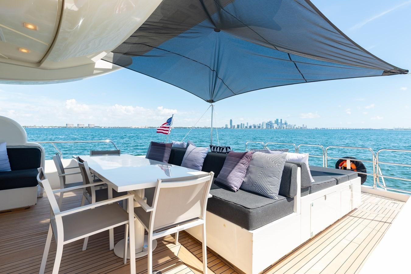 a patio with chairs and an umbrella aboard VENTURE Yacht for Sale