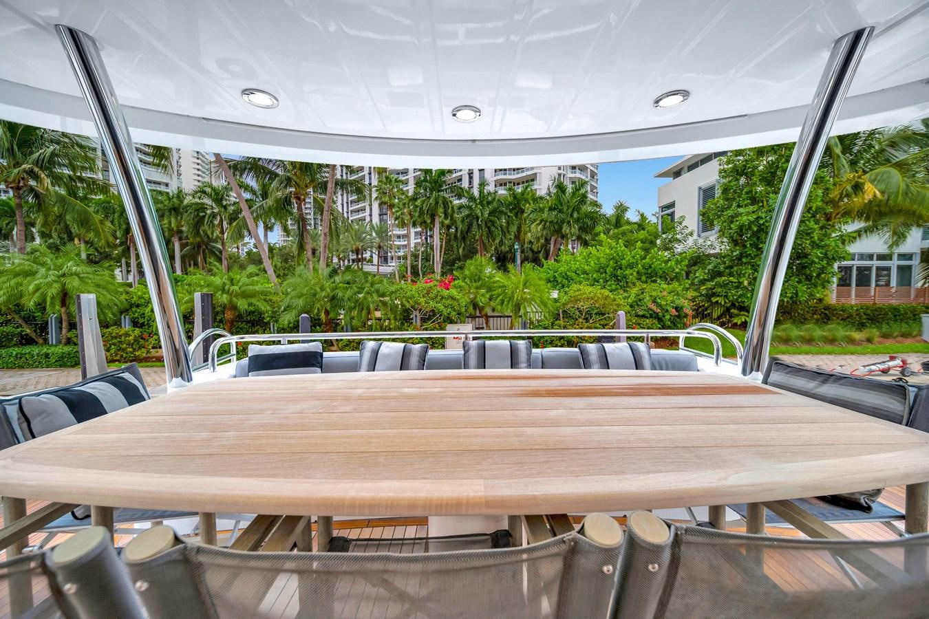 a wooden table with chairs and a large window with trees in the background aboard QUATTRO Yacht for Sale