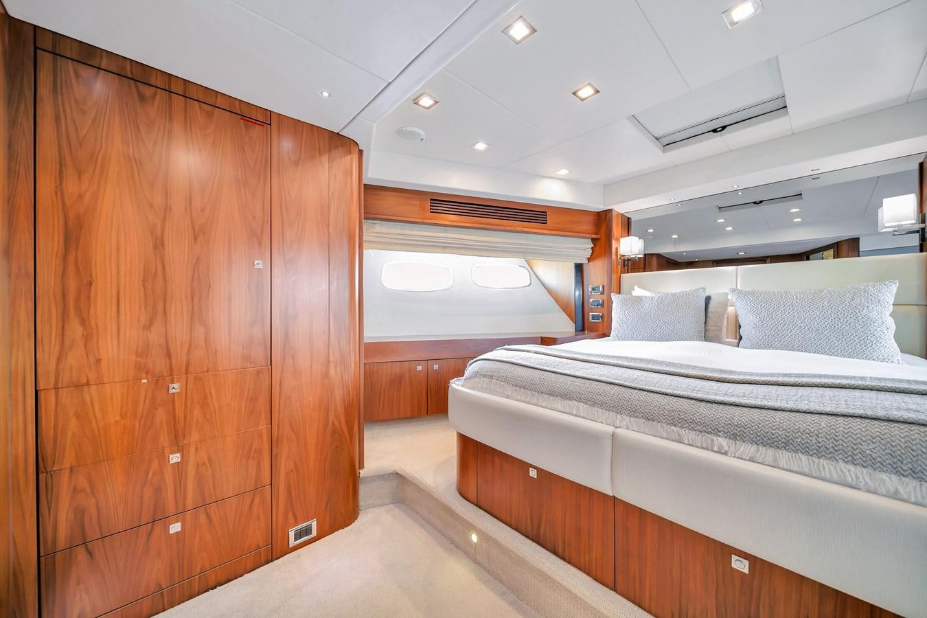 a room with a bed and a wood cabinet aboard QUATTRO Yacht for Sale
