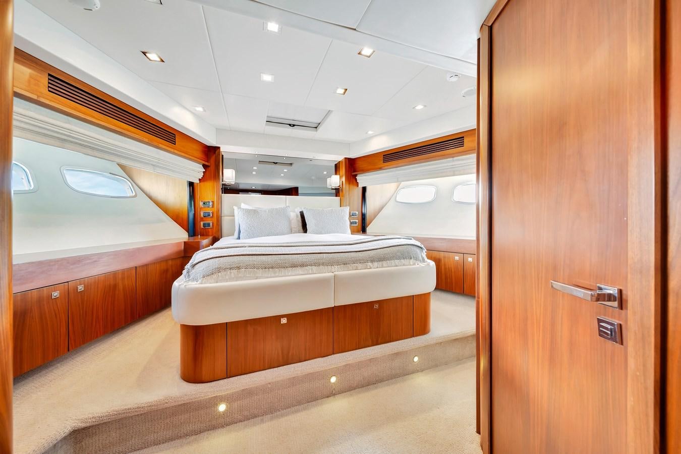 a room with a bed and a wood cabinet aboard QUATTRO Yacht for Sale