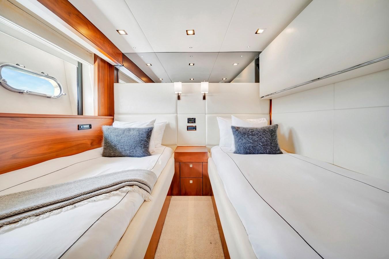 a room with beds and a mirror aboard QUATTRO Yacht for Sale