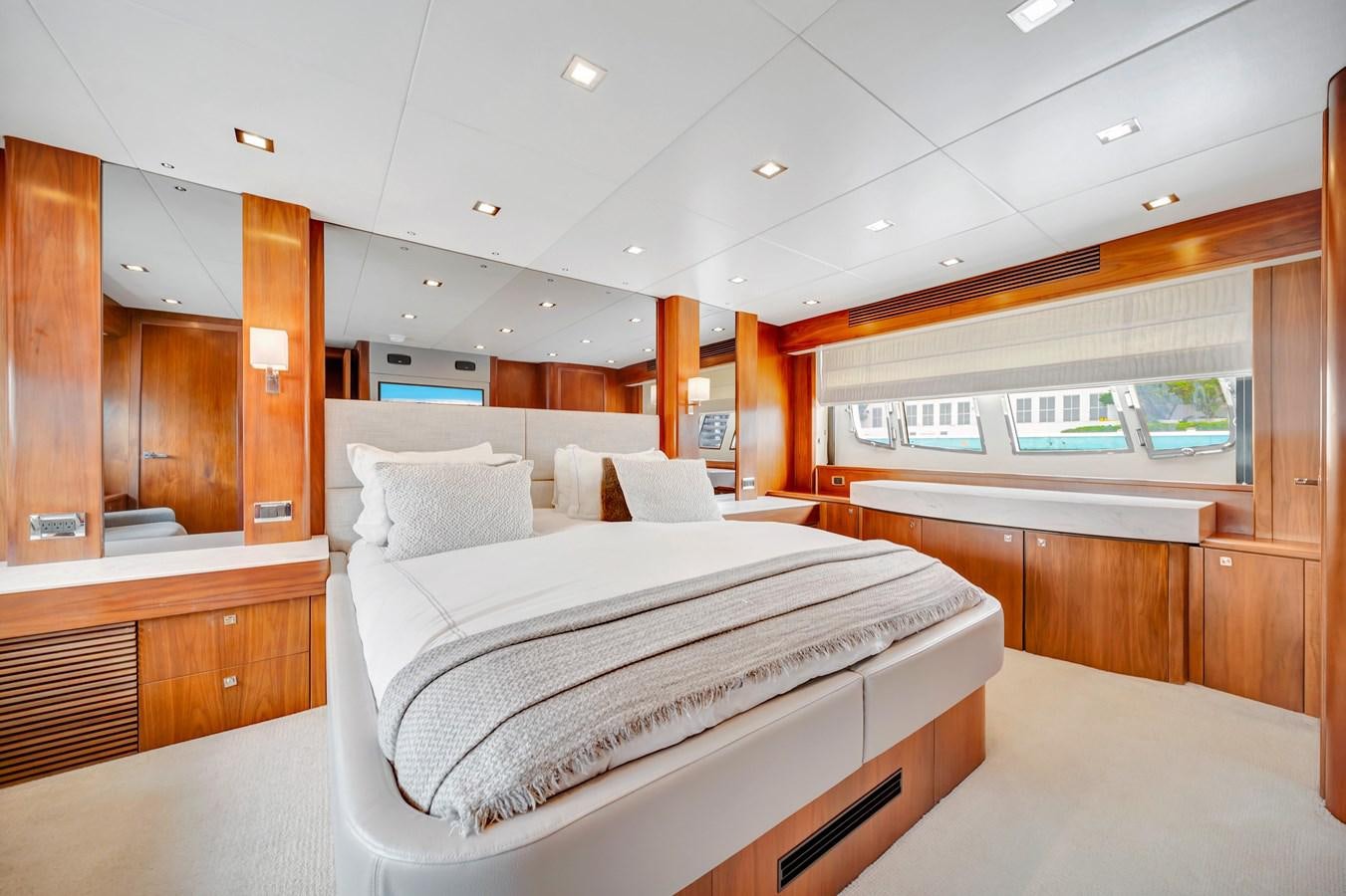 a room with a bed and a wood cabinet aboard QUATTRO Yacht for Sale