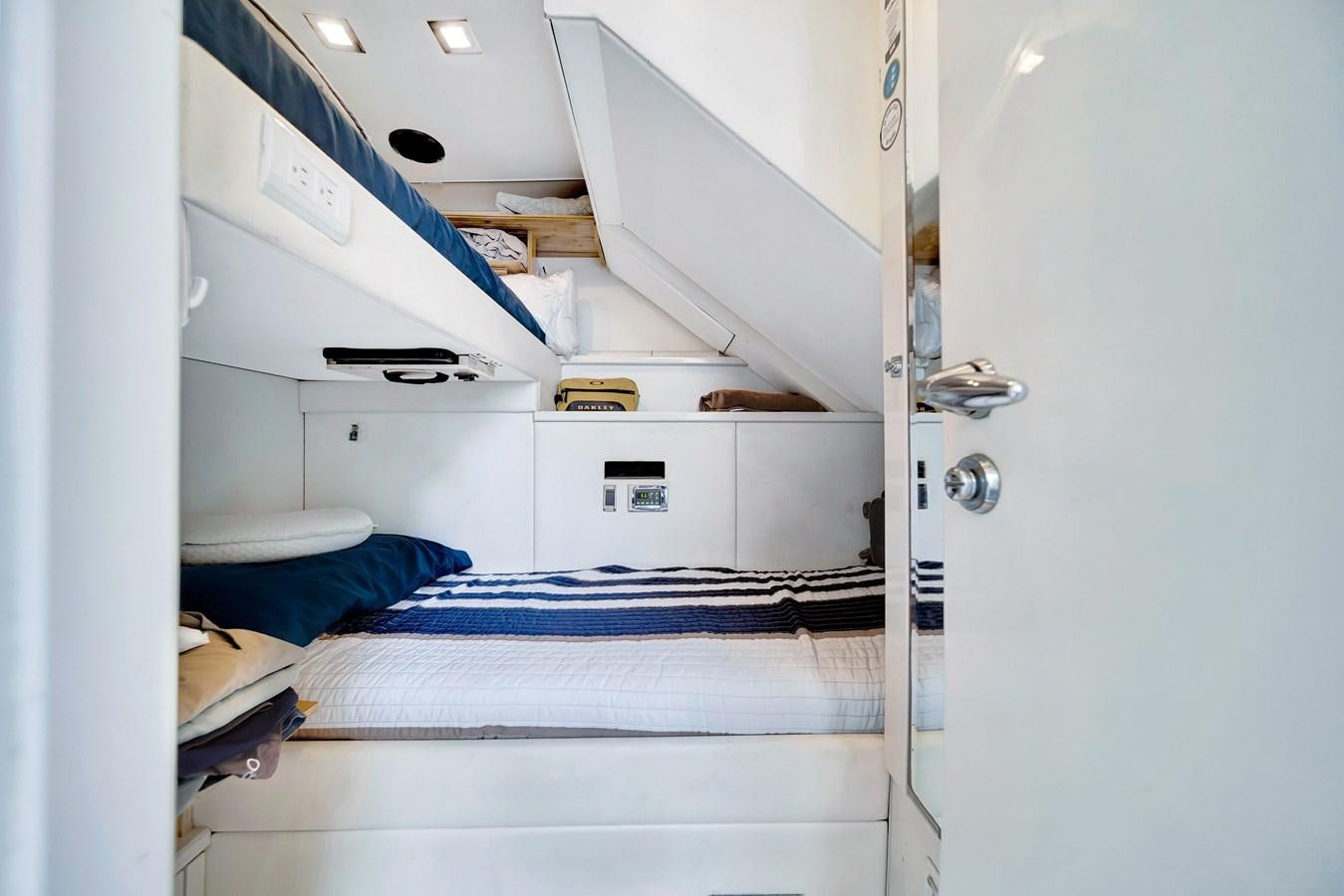 a white bunk bed with a blue sheet on it aboard QUATTRO Yacht for Sale