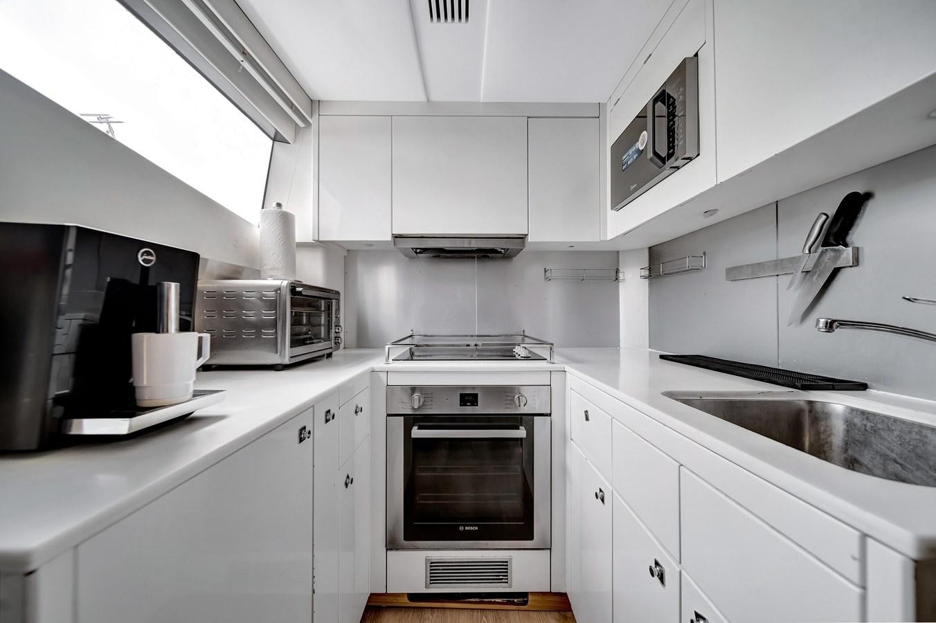 a kitchen with white cabinets aboard QUATTRO Yacht for Sale