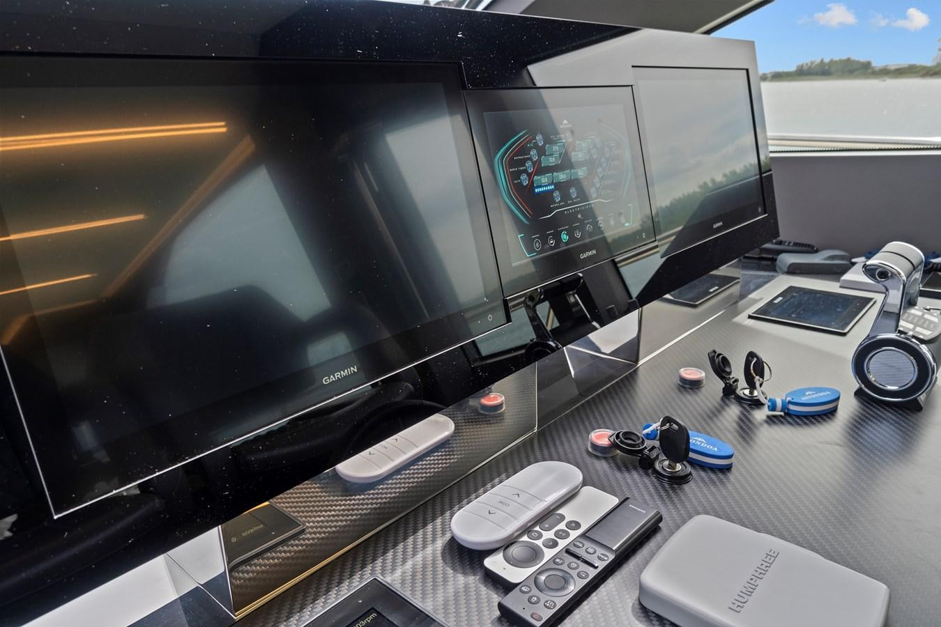 a desk with a computer and remotes on it aboard SAN PEDRO Yacht for Sale