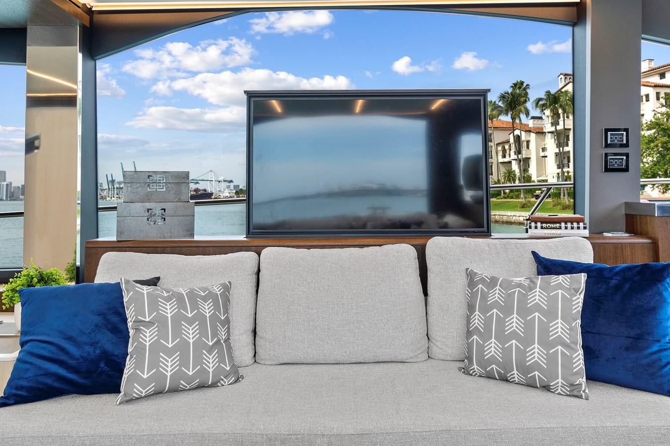 a couch with pillows in front of a large television aboard SAN PEDRO Yacht for Sale