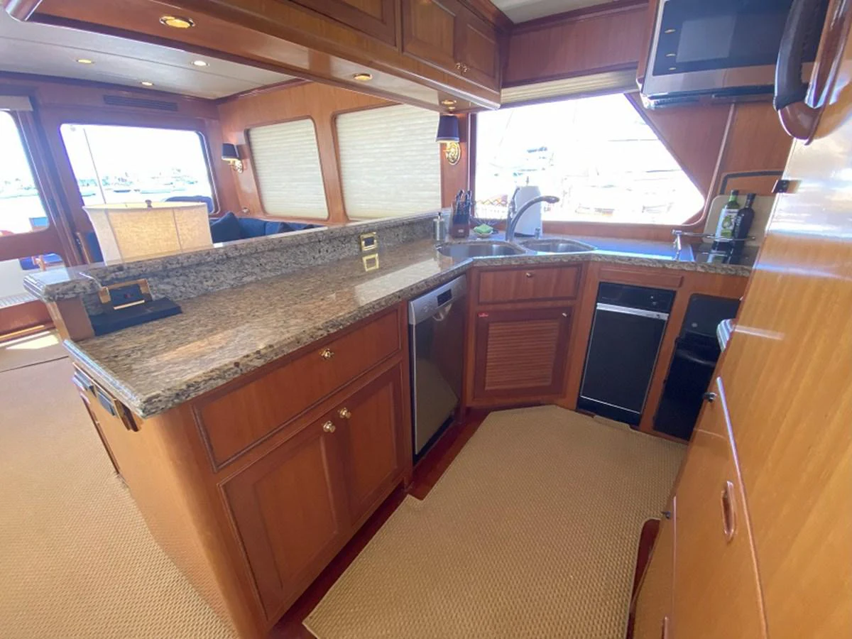 a kitchen with wooden cabinets aboard TEMPUS FUGIT II Yacht for Sale