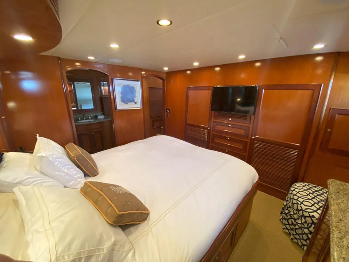 a hotel room with a bed and television aboard TEMPUS FUGIT II Yacht for Sale