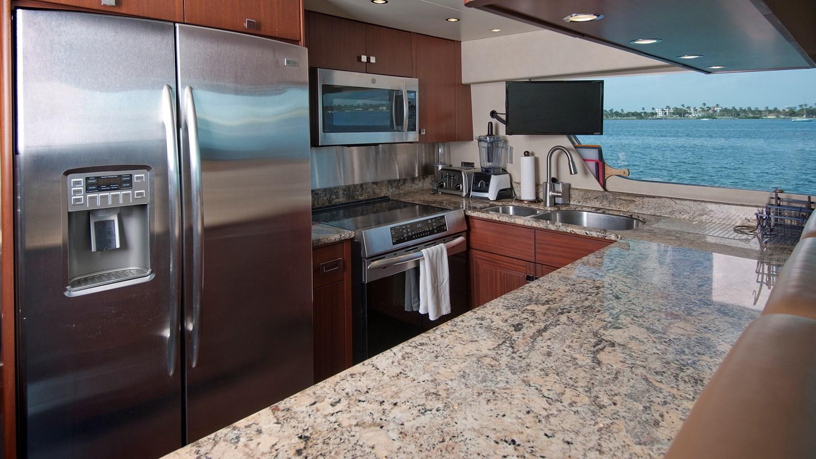 a large kitchen with a large stainless steel refrigerator aboard MONCRII Yacht for Sale