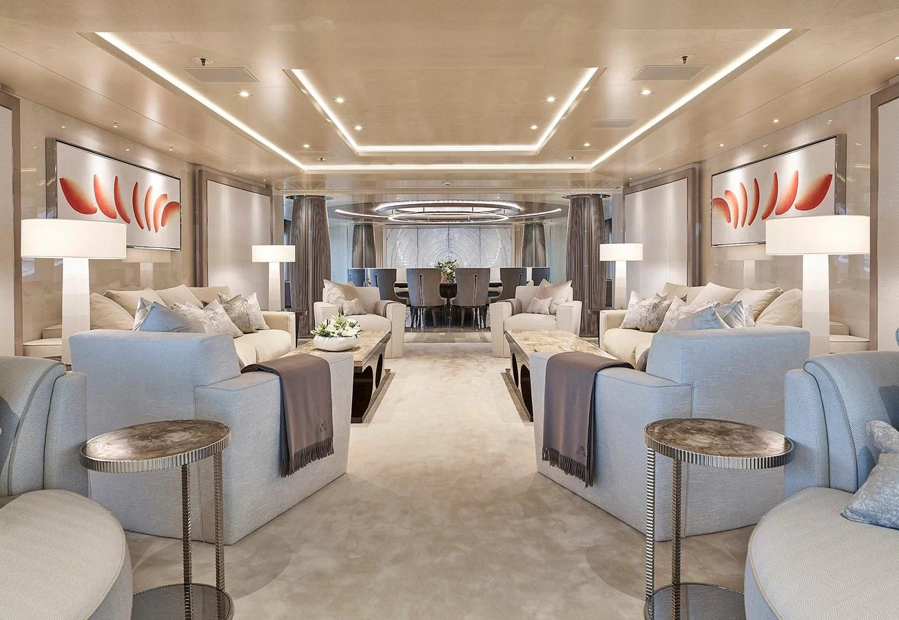 a large living room with a blue couch and white walls aboard NEW SECRET Yacht for Sale