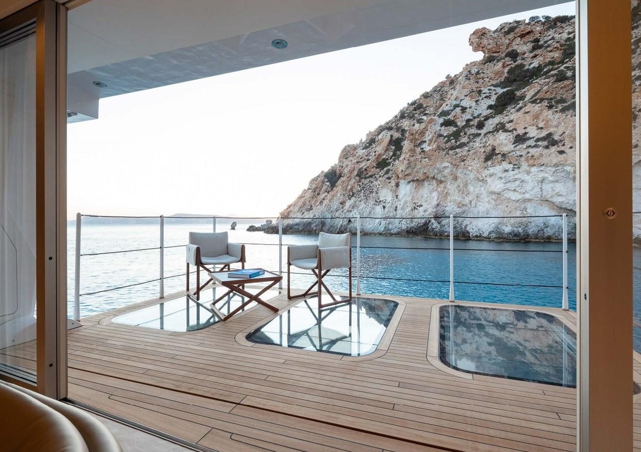 a deck with a view of a mountain and a pool aboard STELLA MI Yacht for Sale