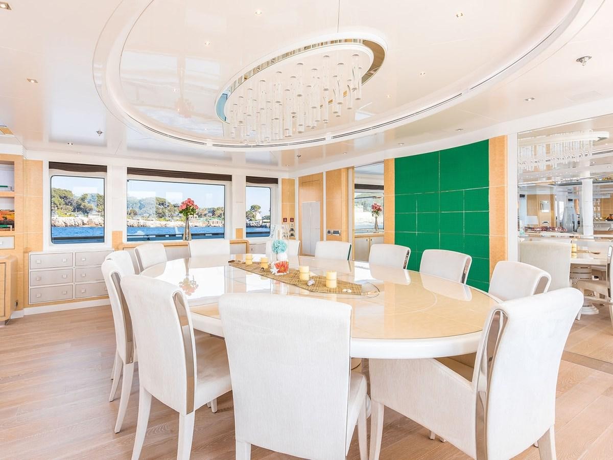 a large dining room with white chairs aboard JADE 959 Yacht for Sale