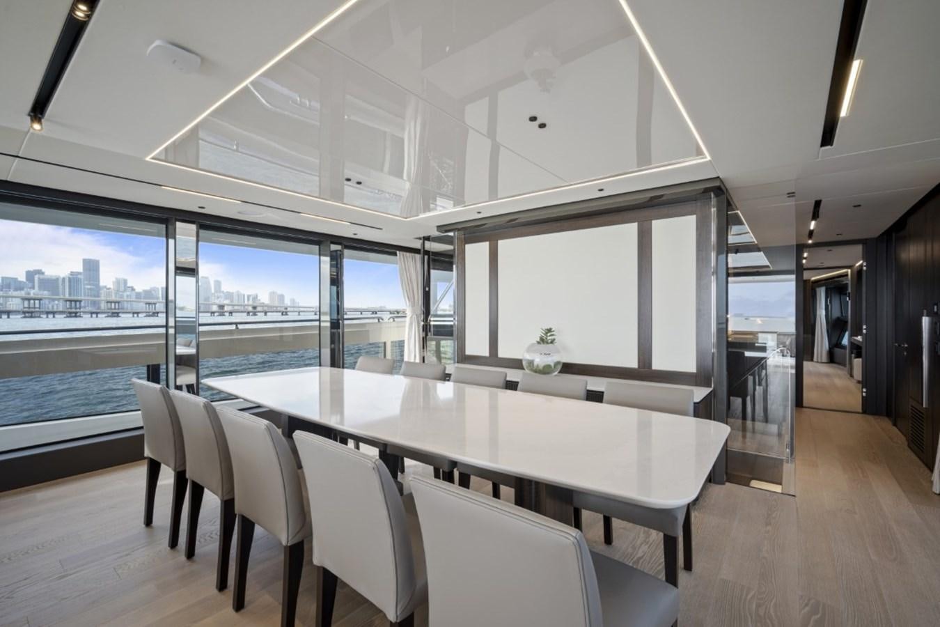 a large dining table in a room with a view of the city aboard SUNSEEKER 90/25 Yacht for Sale