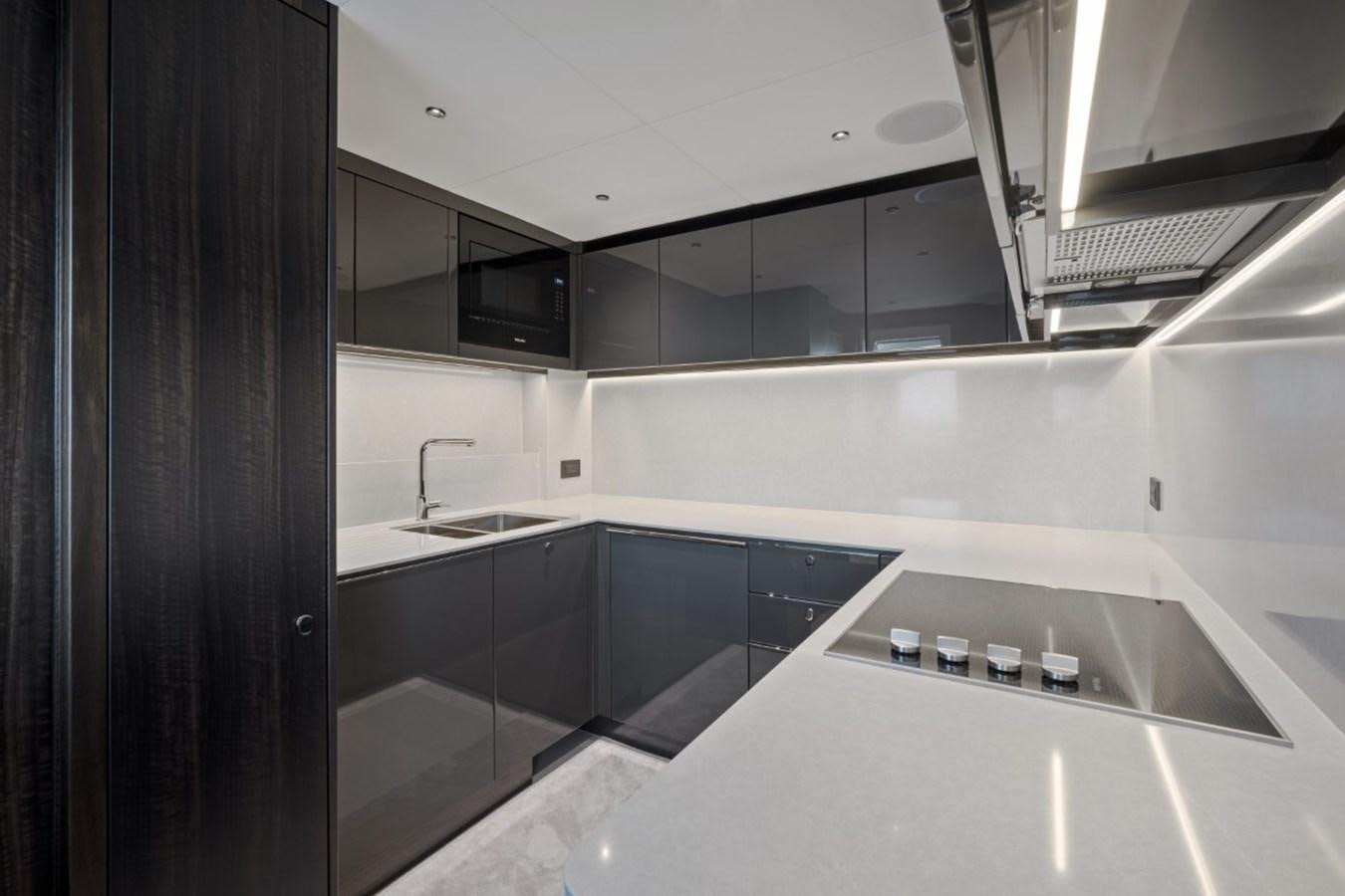 a kitchen with black cabinets aboard SUNSEEKER 90/25 Yacht for Sale