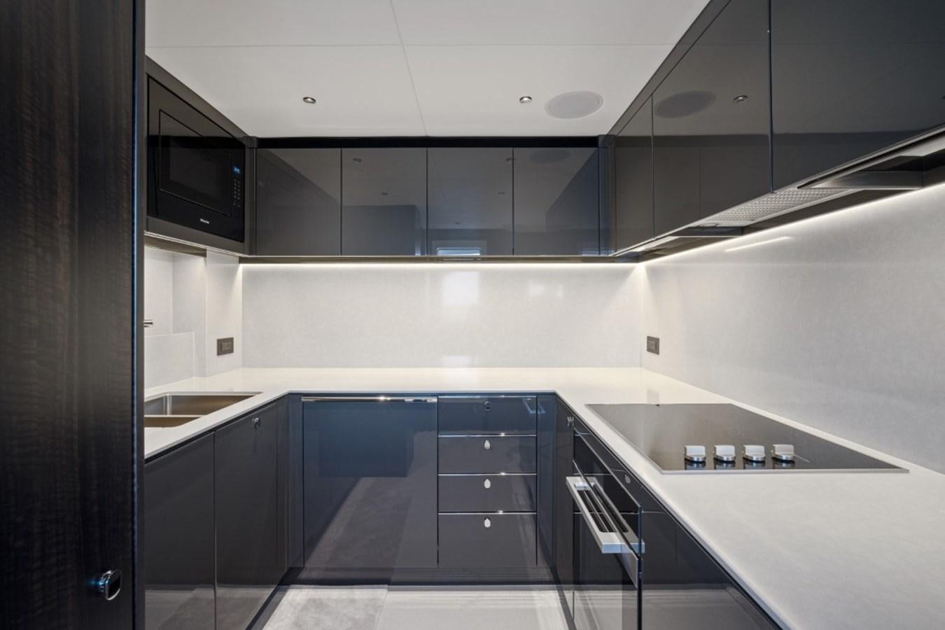a kitchen with black cabinets aboard SUNSEEKER 90/25 Yacht for Sale