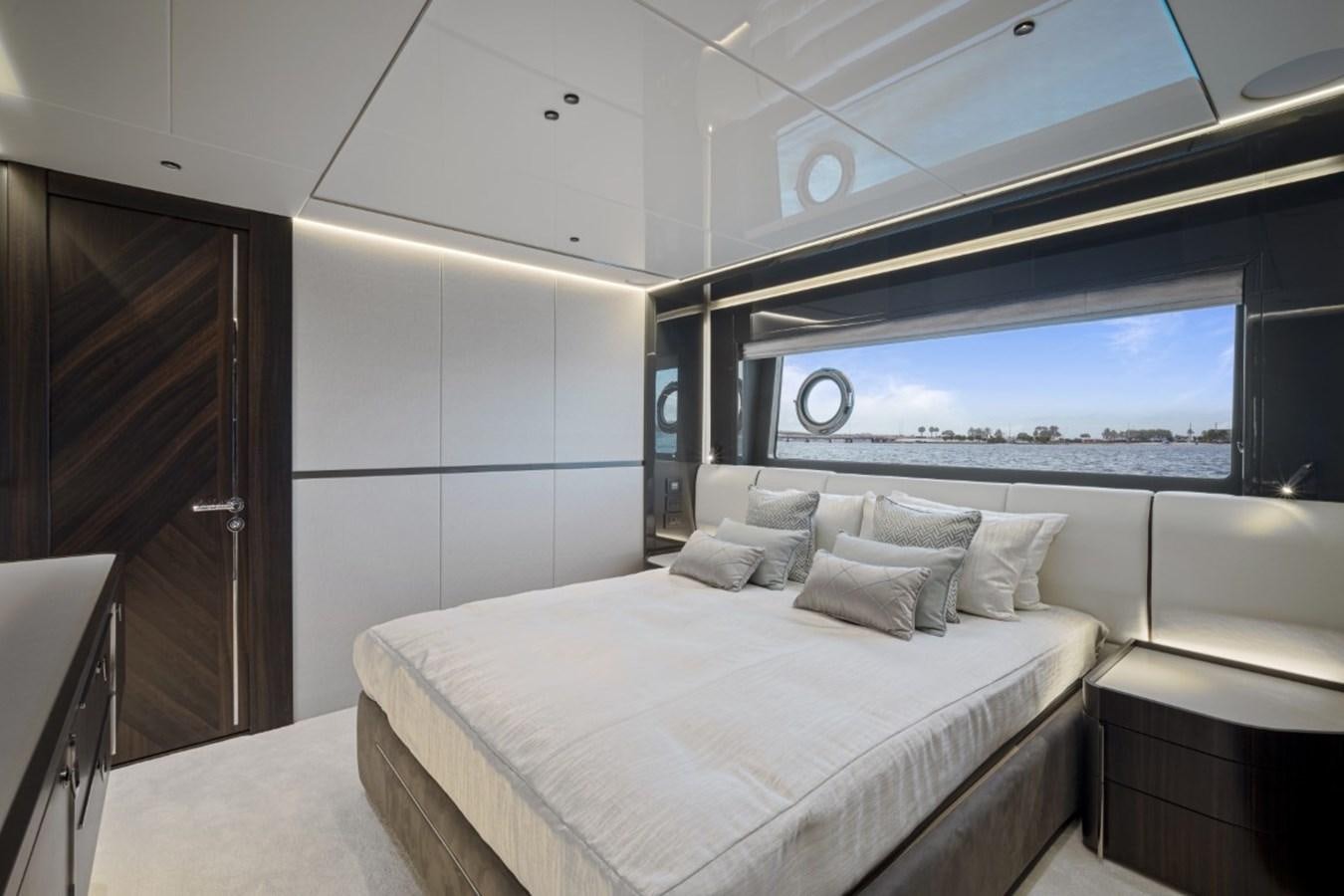 a room with a bed and a large window aboard SUNSEEKER 90/25 Yacht for Sale