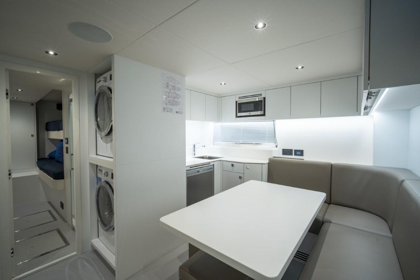 a white kitchen with a white table aboard SUNSEEKER 90/25 Yacht for Sale