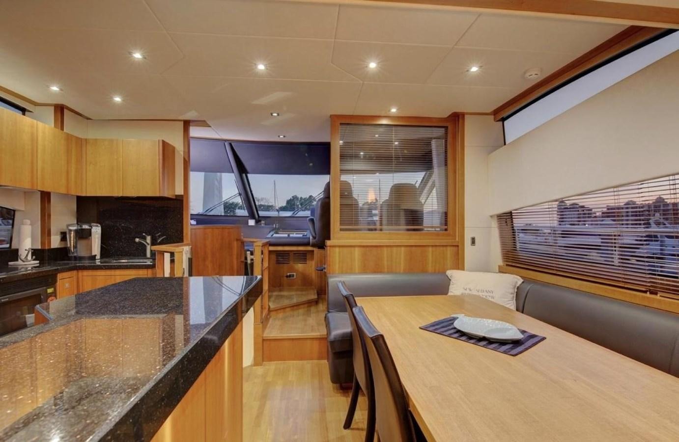 a kitchen with a table and a large window aboard SUNSEEKER 74 2012 SEA C Yacht for Sale