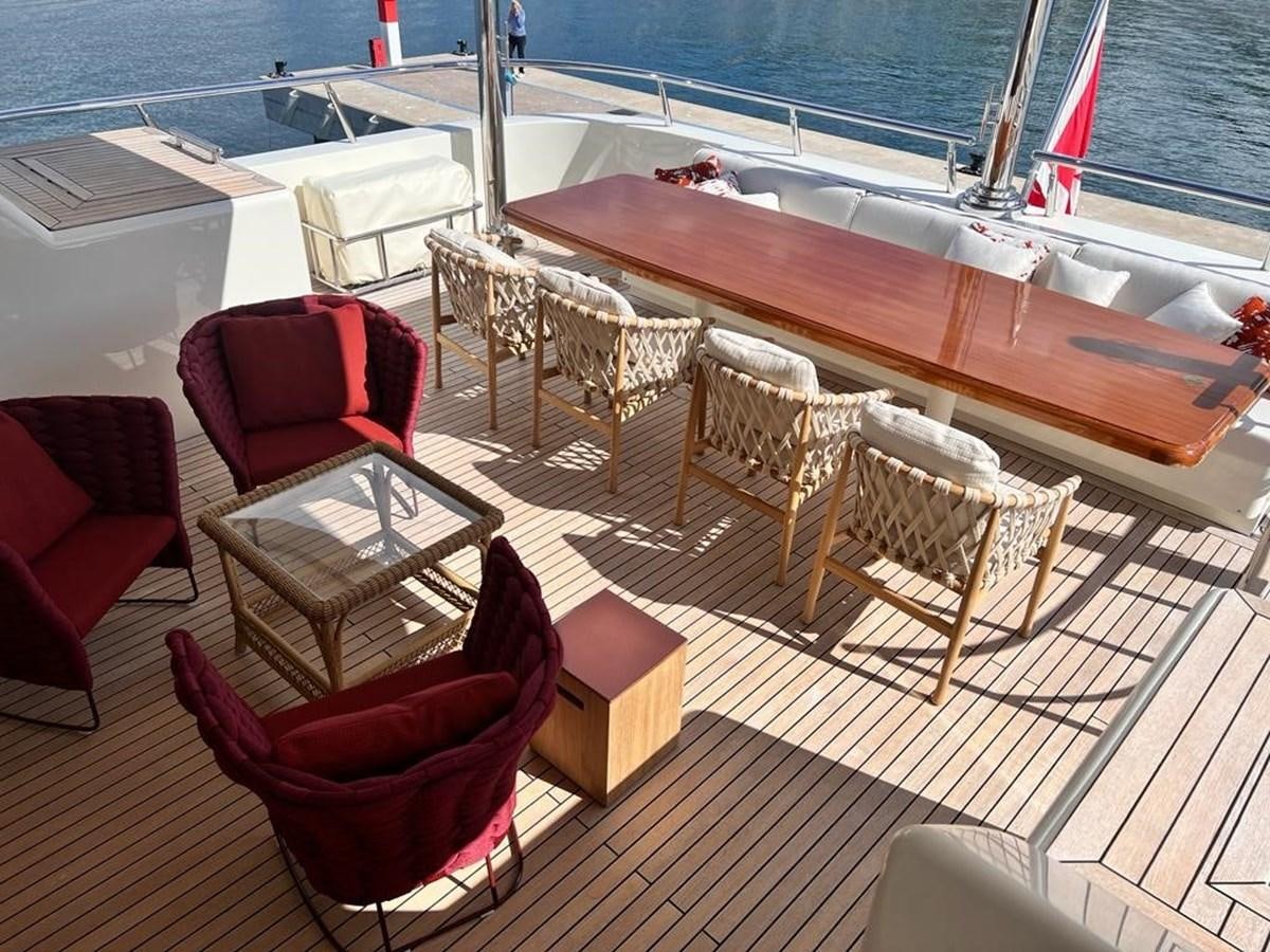 a deck with chairs and a table on it aboard O Yacht for Sale