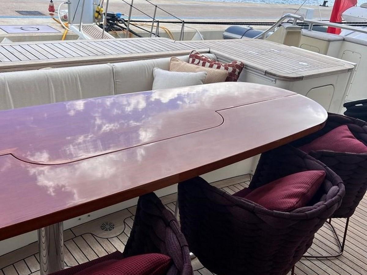 a large wooden table with a red cloth on it aboard O Yacht for Sale