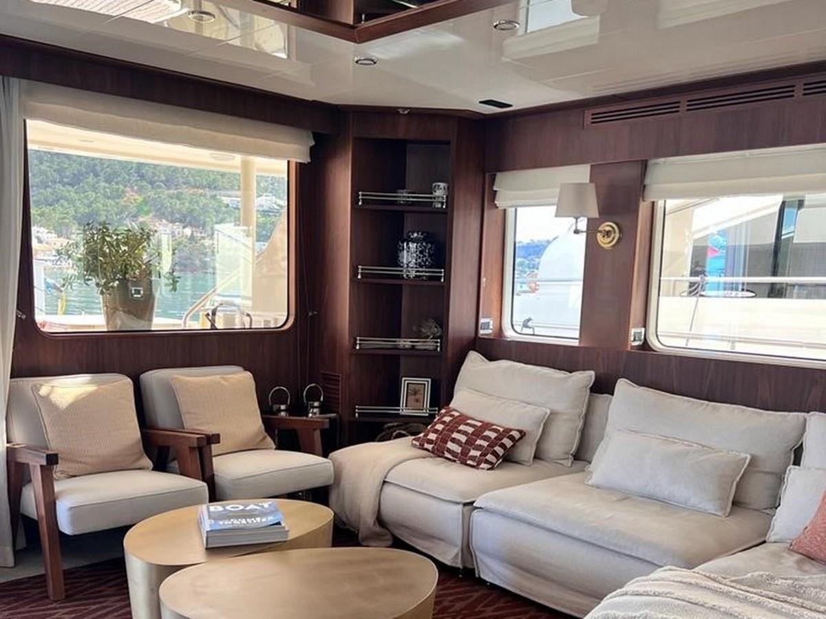 a living room with a couch and a bookcase aboard O Yacht for Sale