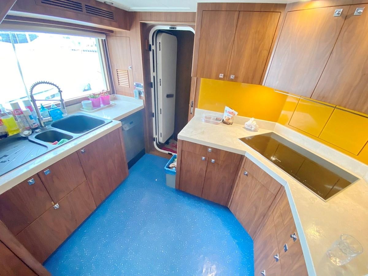 a kitchen with wooden cabinets aboard O Yacht for Sale