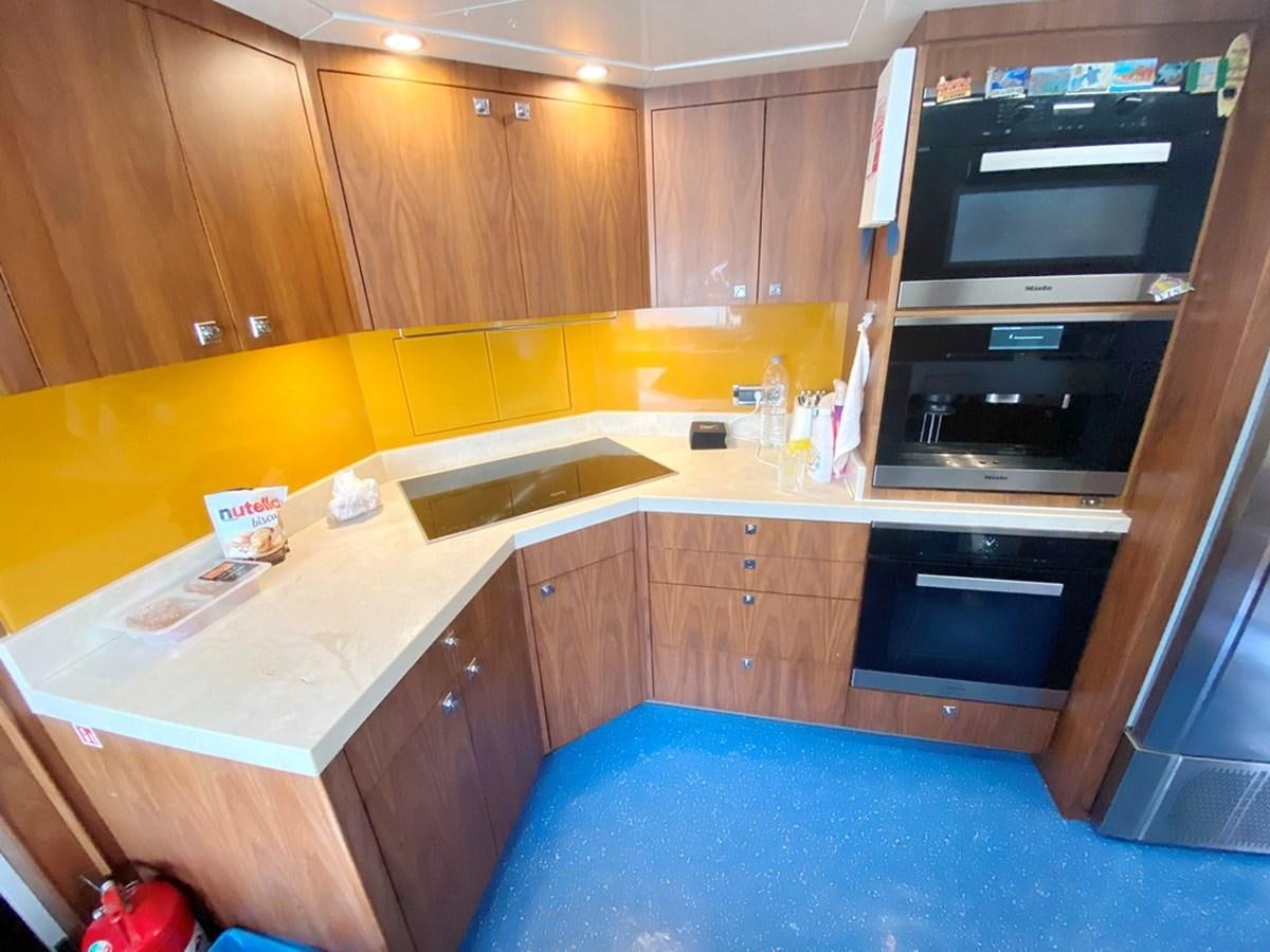 a kitchen with wooden cabinets aboard O Yacht for Sale