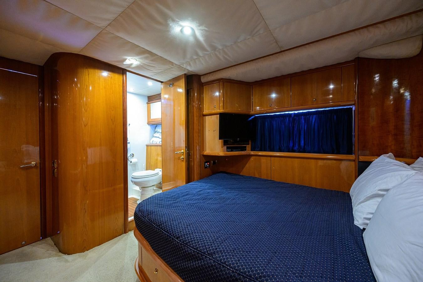 a bedroom with a bed and a wood door aboard MISTRAL Yacht for Sale