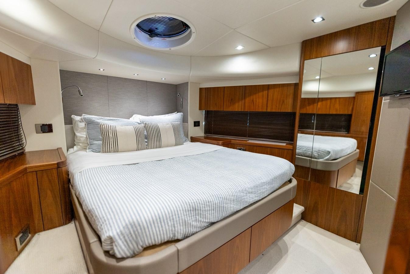 a bedroom with a bed and a mirror aboard SHANTI Yacht for Sale