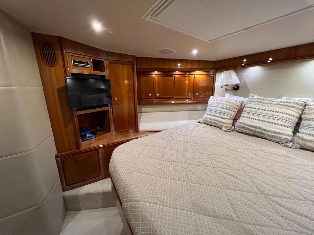 a bedroom with a bed and television aboard BEACH BUM Yacht for Sale