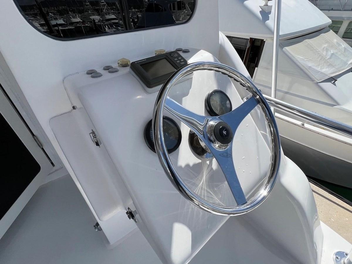 a white machine with a blue steering wheel aboard BEACH BUM Yacht for Sale