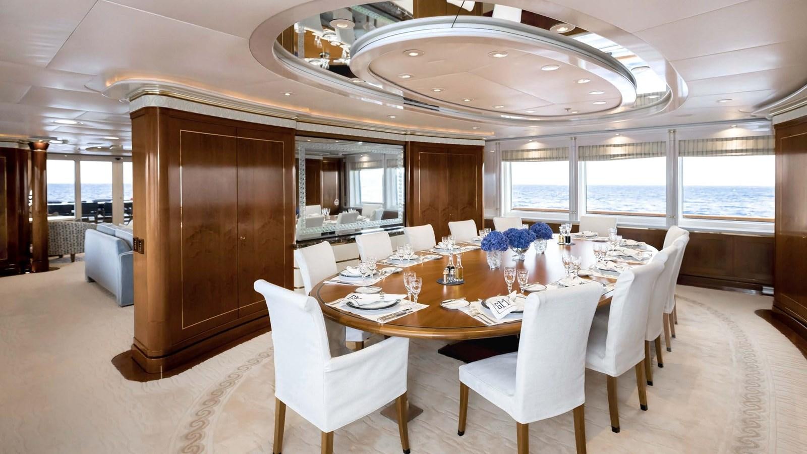 a large room with a table and chairs aboard OLYMPUS Yacht for Sale