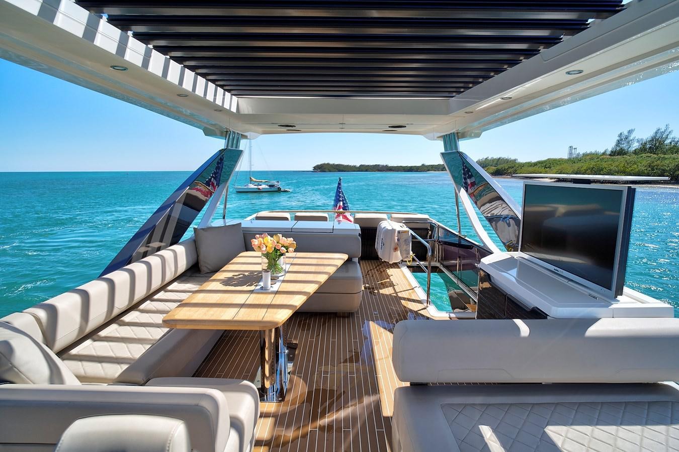 a deck with a table and chairs on it aboard RAW WAVE Yacht for Sale