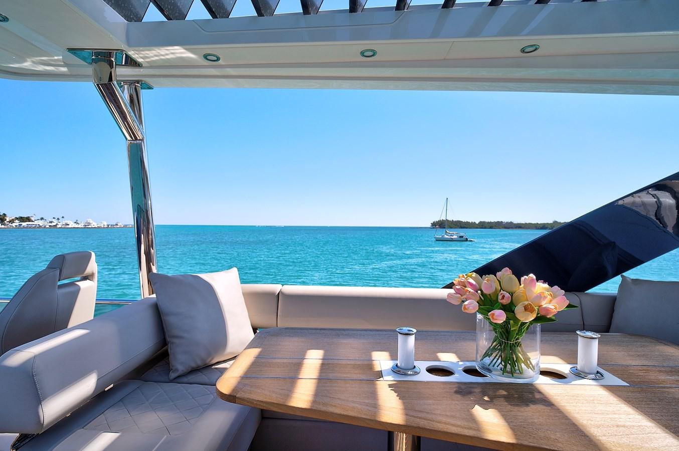 a table with chairs and a view of the ocean aboard RAW WAVE Yacht for Sale