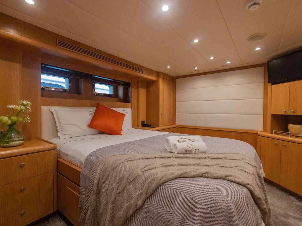 a bedroom with a bed and a tv on the wall aboard BANDIDO I Yacht for Sale