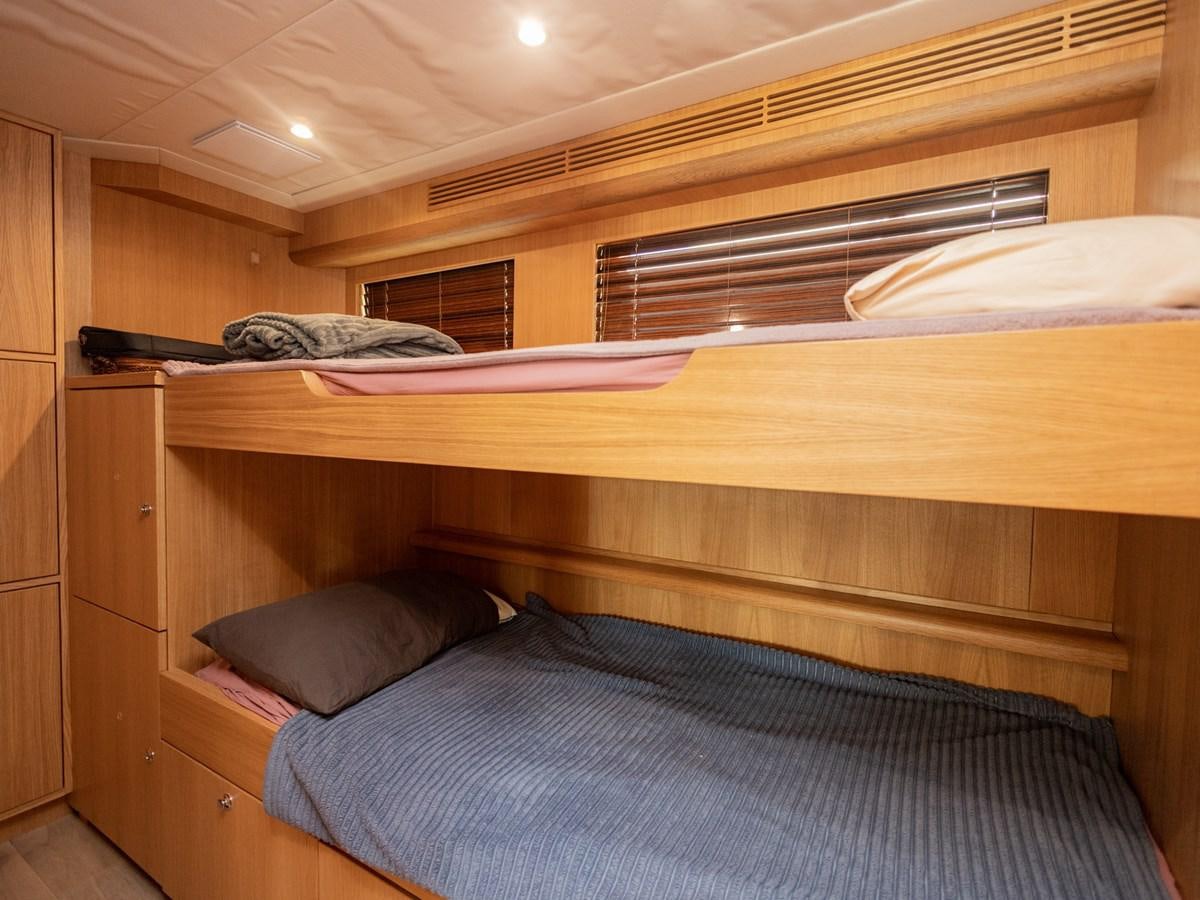 a bed with a wooden headboard aboard BANDIDO I Yacht for Sale