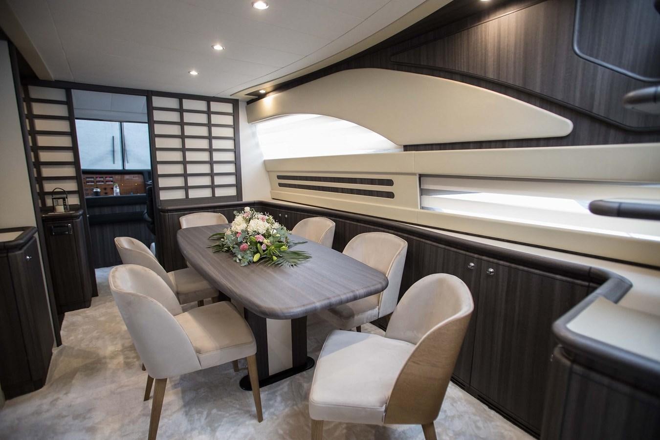 a modern looking kitchen with a dining table and chairs aboard SOFIA D Yacht for Sale