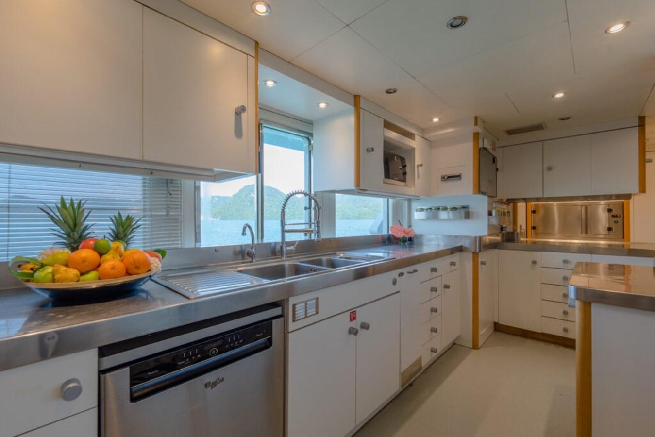 a kitchen with white cabinets aboard AZUL V Yacht for Sale