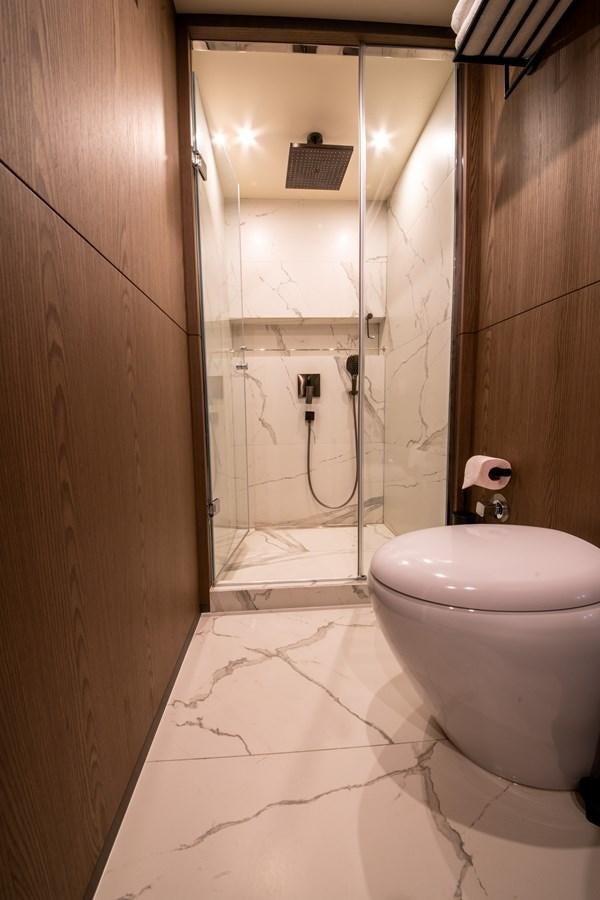 a bathroom with a glass shower aboard PURA-VIDA Yacht for Sale