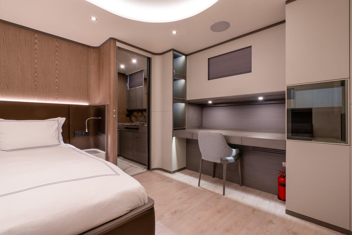 a bedroom with a bed and a desk aboard PURA-VIDA Yacht for Sale