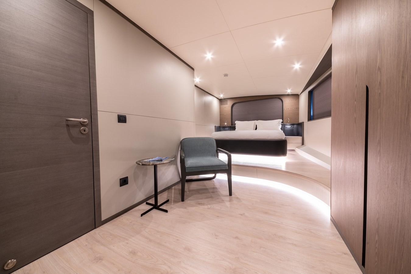 a room with a bed and a chair aboard PURA-VIDA Yacht for Sale