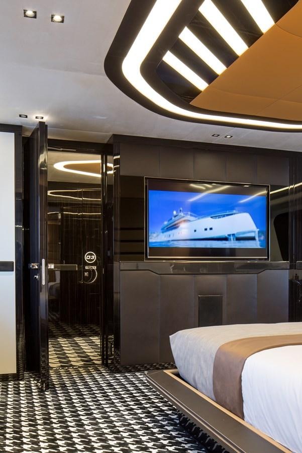 a room with a bed and a tv on the wall aboard DYNAMIQ GTT 115  Yacht for Sale
