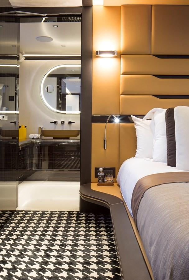 a room with a bed and a mirror aboard DYNAMIQ GTT 115  Yacht for Sale